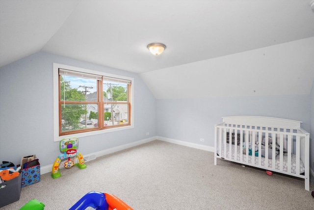 bedroom with carpet flooring, lofted ceiling, and a nursery area