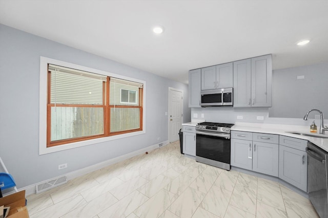 kitchen featuring gray cabinetry, sink, and stainless steel appliances