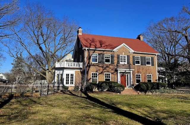 colonial home with a balcony and a front lawn