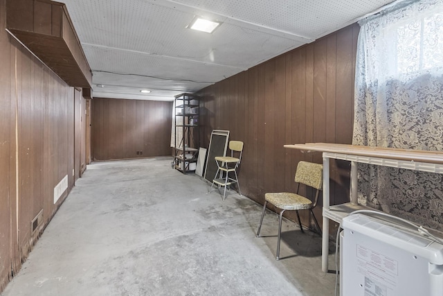 basement with wooden walls and bar area