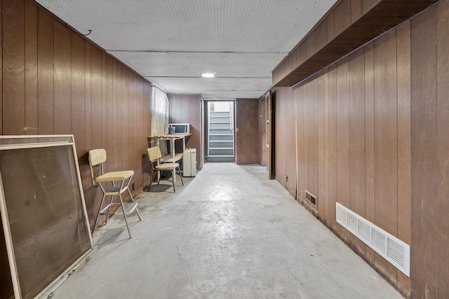 basement featuring wooden walls