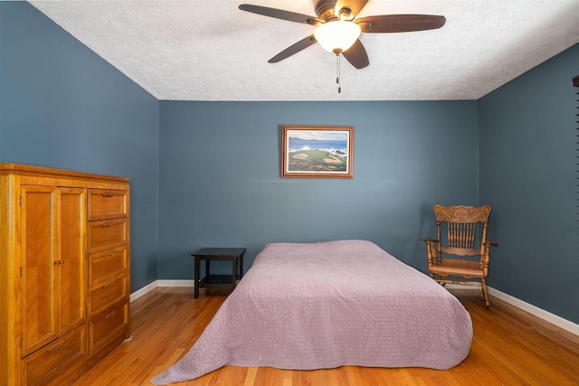 bedroom featuring a textured ceiling, light hardwood / wood-style flooring, and ceiling fan