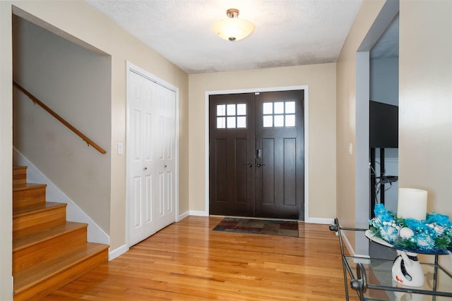 entryway featuring a textured ceiling and light hardwood / wood-style floors