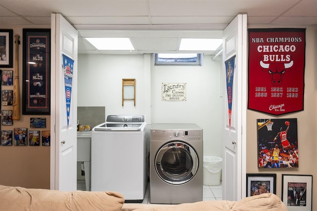 clothes washing area featuring tile patterned flooring and independent washer and dryer