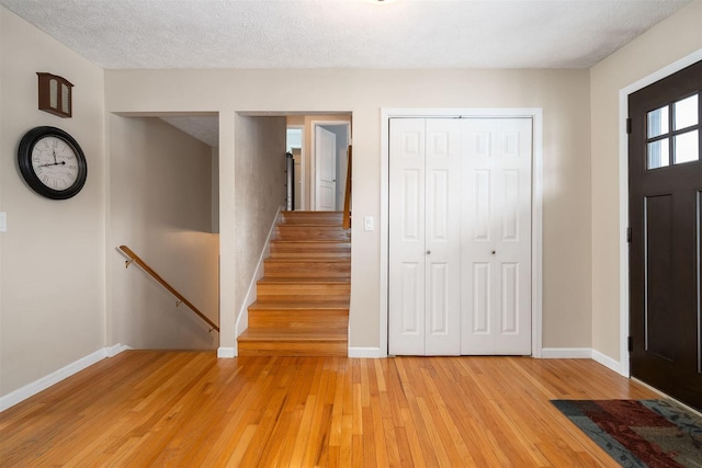 foyer featuring a textured ceiling and light wood-type flooring