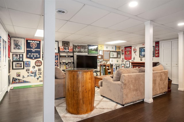 living room featuring a paneled ceiling and hardwood / wood-style flooring