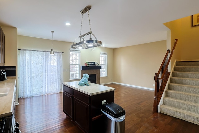 kitchen with dark hardwood / wood-style flooring, a center island, and decorative light fixtures