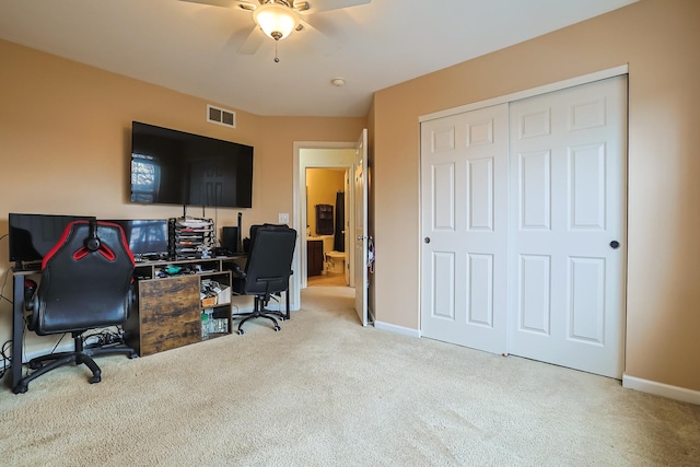 carpeted office space featuring ceiling fan