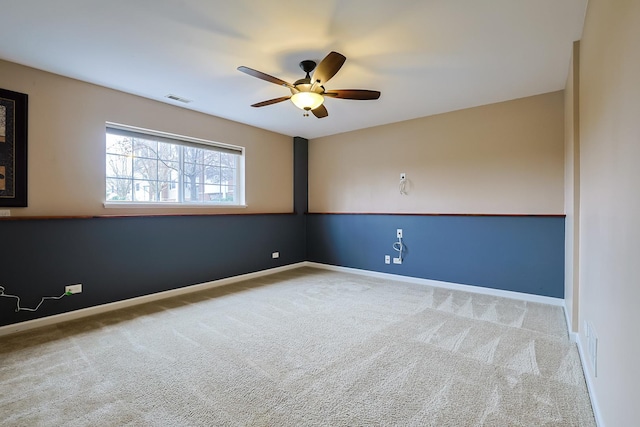 spare room with ceiling fan and carpet