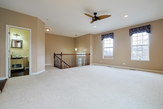 carpeted spare room with ceiling fan