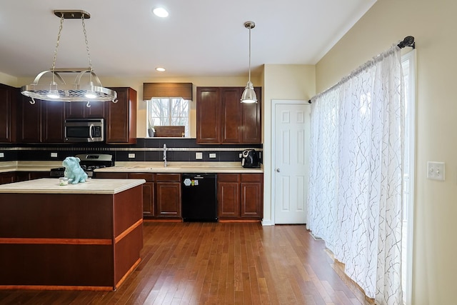 kitchen with pendant lighting, sink, dark hardwood / wood-style floors, tasteful backsplash, and stainless steel appliances