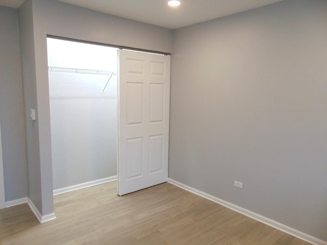 unfurnished bedroom featuring light wood-type flooring and a closet