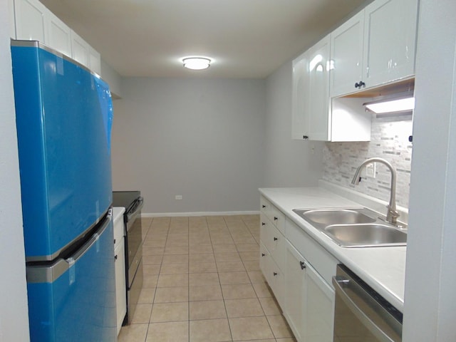 kitchen featuring white cabinetry, sink, decorative backsplash, light tile patterned flooring, and appliances with stainless steel finishes