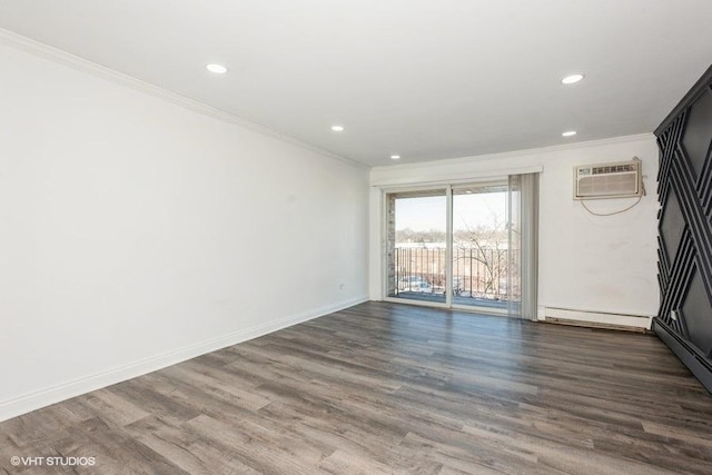 unfurnished room with crown molding, dark wood-type flooring, a wall unit AC, and a baseboard heating unit