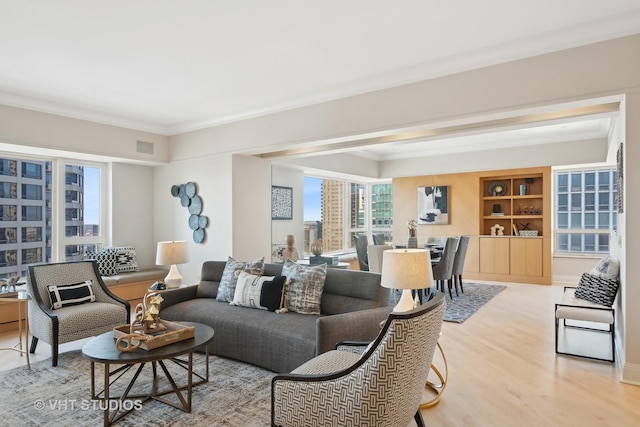 living area with visible vents, ornamental molding, light wood-style flooring, and a city view