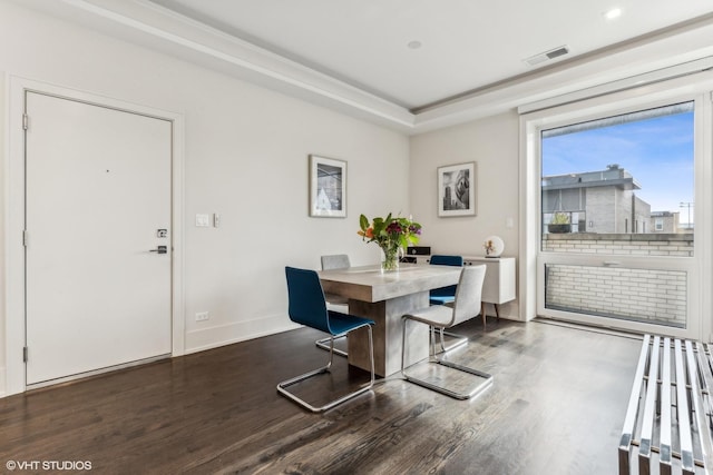 dining space with a tray ceiling and dark wood-type flooring