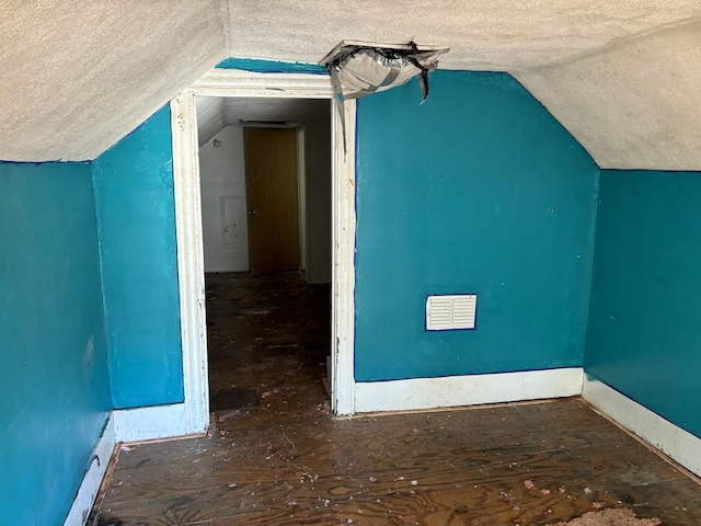 bonus room featuring a textured ceiling and lofted ceiling