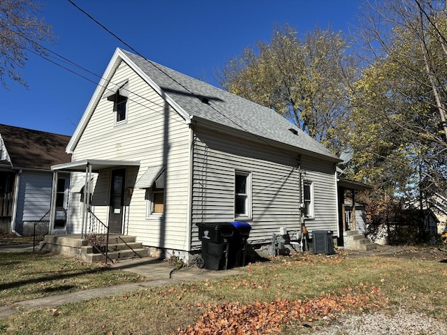 view of side of property featuring a yard and central AC unit