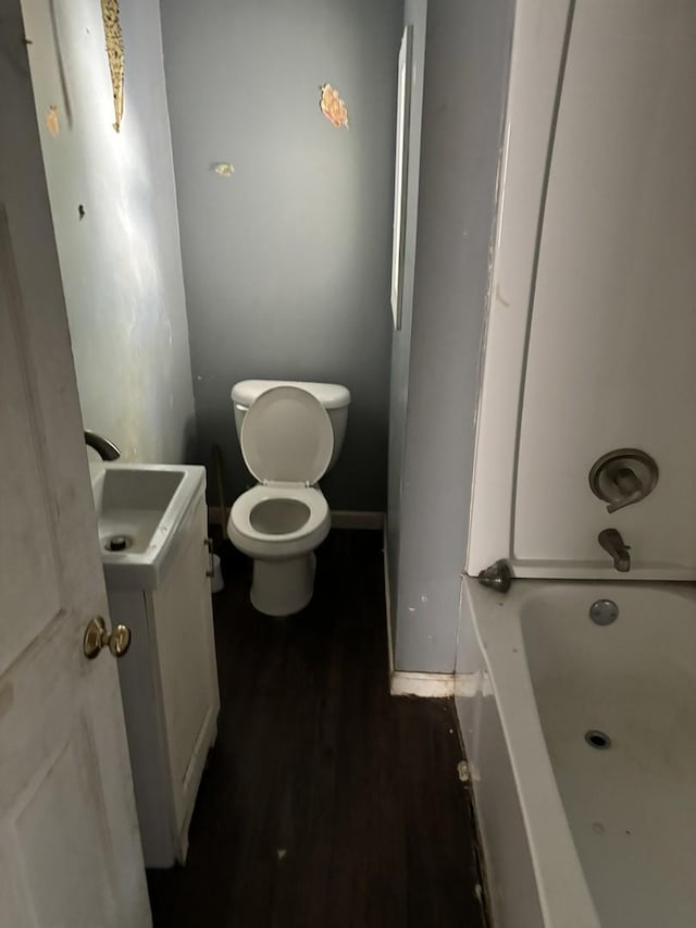 bathroom featuring toilet, vanity, and hardwood / wood-style flooring