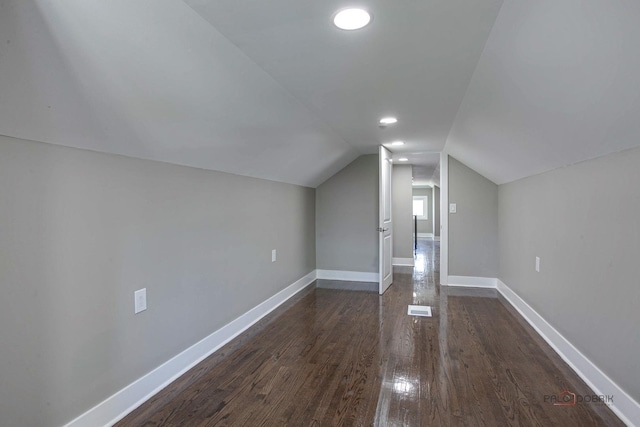 bonus room with dark hardwood / wood-style floors and vaulted ceiling