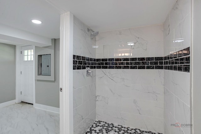 bathroom with a tile shower and electric panel