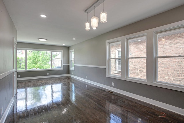 unfurnished room with dark wood-type flooring and an inviting chandelier