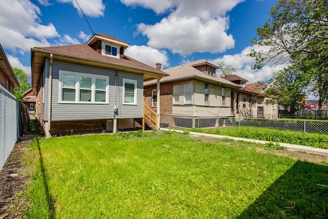 rear view of property featuring a lawn