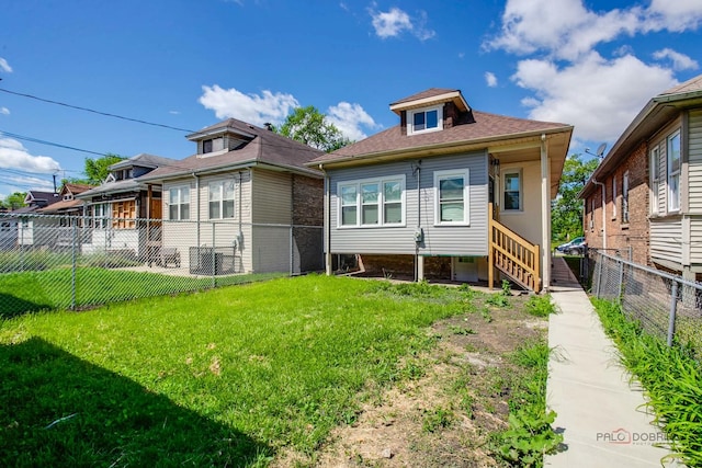 rear view of property featuring a lawn