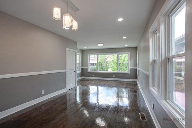 empty room featuring dark hardwood / wood-style flooring and a chandelier