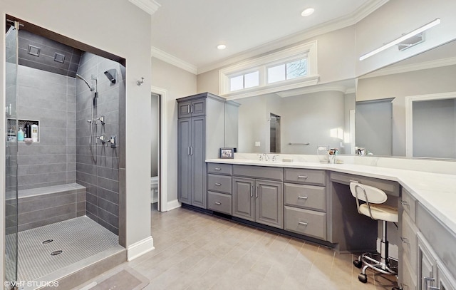 bathroom with a tile shower, vanity, and crown molding