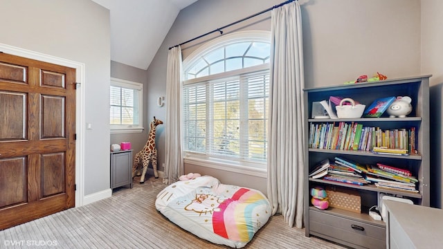 interior space featuring light colored carpet, a wealth of natural light, and vaulted ceiling