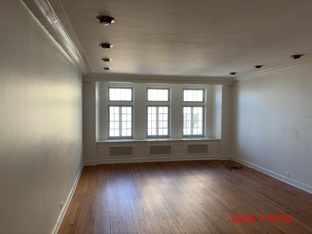 unfurnished room featuring ornamental molding and dark hardwood / wood-style floors