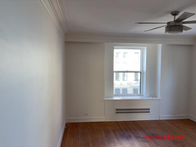 unfurnished room with dark hardwood / wood-style flooring, ceiling fan, and crown molding