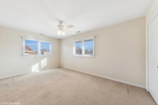 carpeted spare room featuring ceiling fan