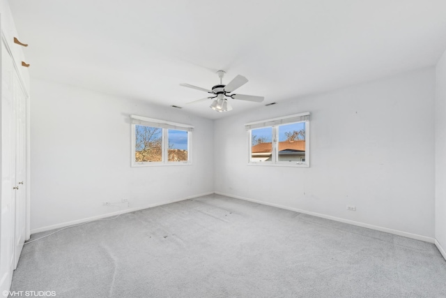 carpeted spare room featuring ceiling fan