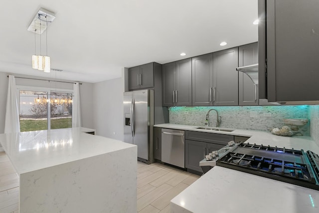 kitchen featuring gray cabinetry, sink, decorative light fixtures, and appliances with stainless steel finishes