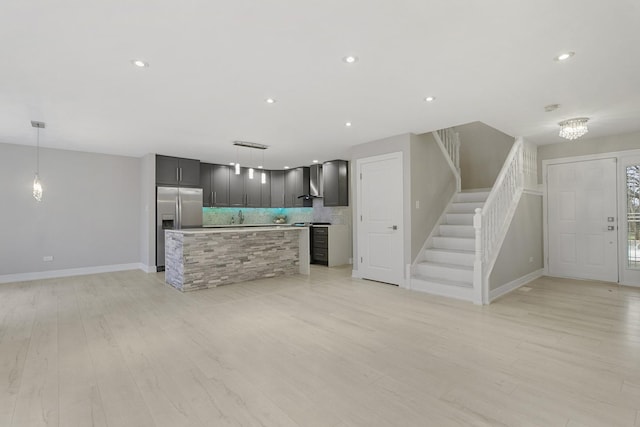 kitchen featuring appliances with stainless steel finishes, tasteful backsplash, a kitchen island, and pendant lighting