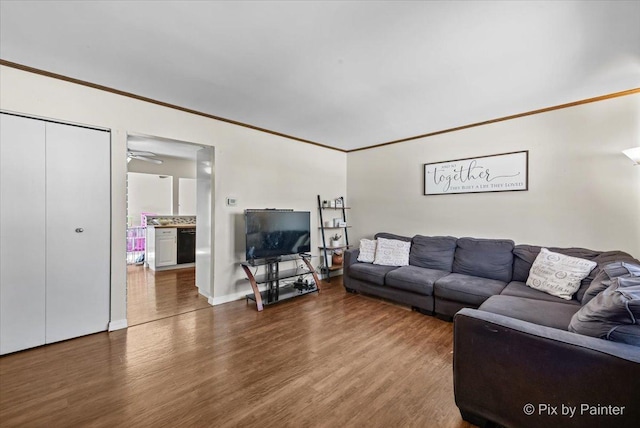 living room featuring ceiling fan, dark hardwood / wood-style floors, and ornamental molding