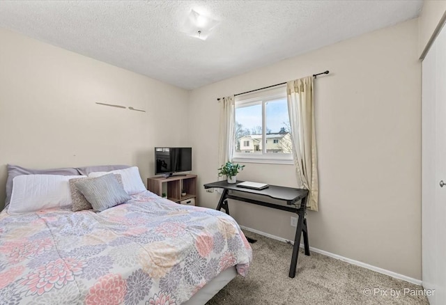 bedroom featuring a textured ceiling, a closet, and light colored carpet