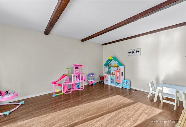 playroom with beam ceiling and wood-type flooring