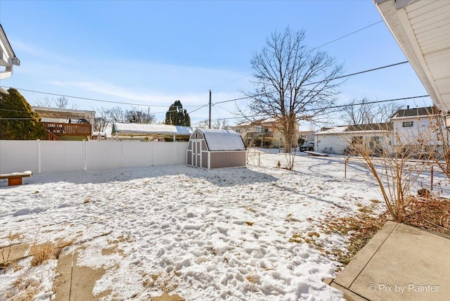 yard layered in snow with a storage unit