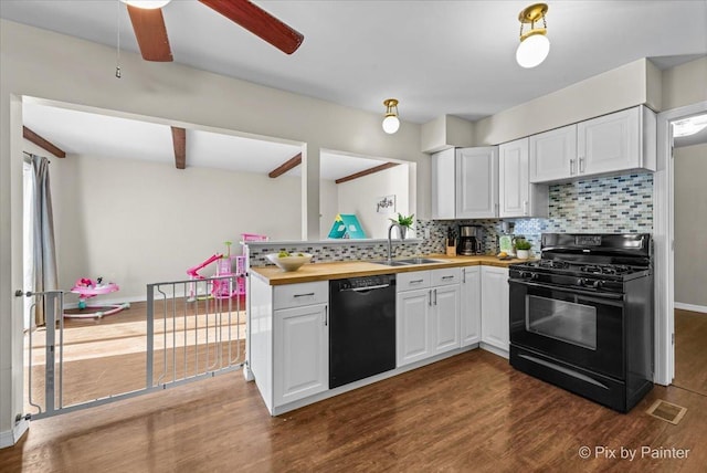 kitchen with white cabinets, black appliances, wooden counters, sink, and backsplash