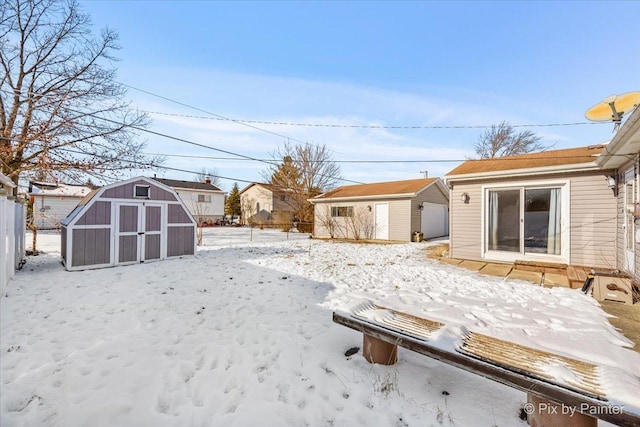 yard covered in snow featuring a shed