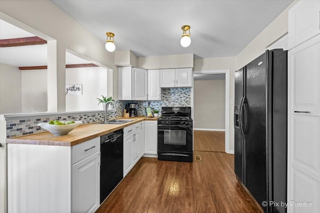 kitchen featuring wood counters, white cabinetry, dark wood-type flooring, black appliances, and sink