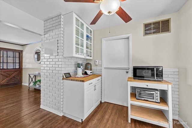 kitchen with ceiling fan, white cabinetry, dark hardwood / wood-style floors, and wooden counters