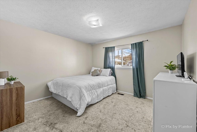 carpeted bedroom featuring a textured ceiling