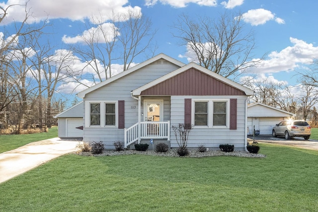 view of front of home with a garage, an outdoor structure, and a front lawn