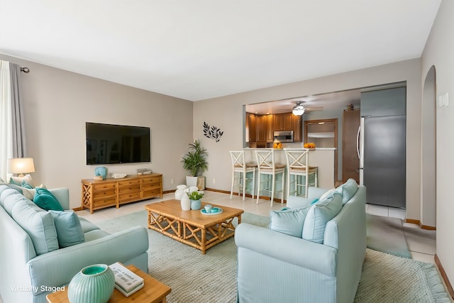 tiled living room with ceiling fan