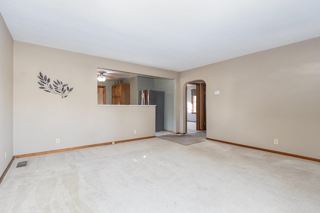 carpeted spare room with ceiling fan