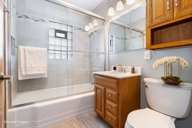 full bathroom with combined bath / shower with glass door, vanity, and toilet